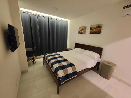 萨利纳斯Suite Chipipe AC Wi-Fi Lavanderia a 1 cuadra mar的一间卧室配有一张床铺,床上有毯子