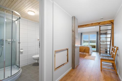 Averoy斯维格维卡旅馆的带淋浴和卫生间的浴室以及一间卧室。