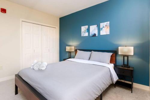 匹兹堡1B1B Cozy Chic in DT Pittsburgh VALET GYM WIFI的一间卧室配有一张白色大床和蓝色的墙壁