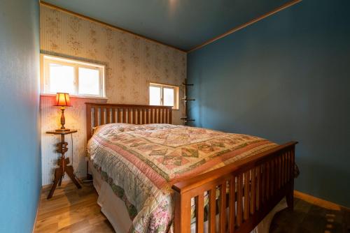大村市鉢巻山荘的一间卧室设有一张床和一个窗口