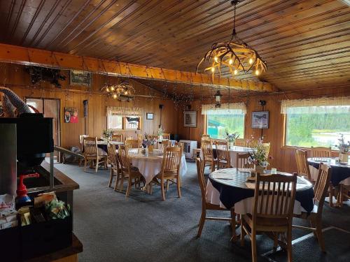 格伦纳伦Tolsona Lake Lodge的一间带桌椅和电视的用餐室