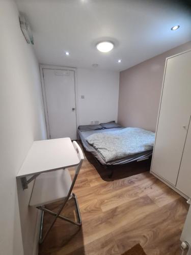 FelthamAmazing 1 bed flat near Heathrow的小房间设有一张床和一张桌子