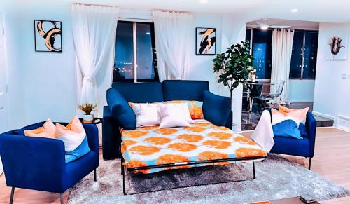 亚特兰大Highrise luxury two bedroom condo in Downtown Atlanta within minutes!!的一间卧室配有一张床和两张蓝色椅子