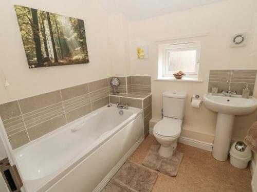 GlantonRamblers Cottage的带浴缸、卫生间和盥洗盆的浴室