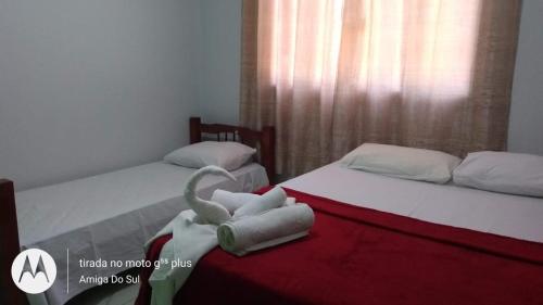 诺布里斯Pousada Canto das Araras - Vila Bom Jardim Nobres MT的客房内的两张床和毛巾