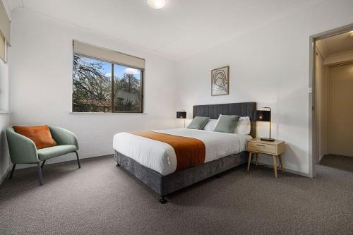 堪培拉奥克斯利阁服务公寓的卧室配有床、椅子和窗户。