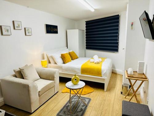 伦敦Premium Studio Flat 04 in Central London的一间卧室配有一张床、一张沙发和一张桌子