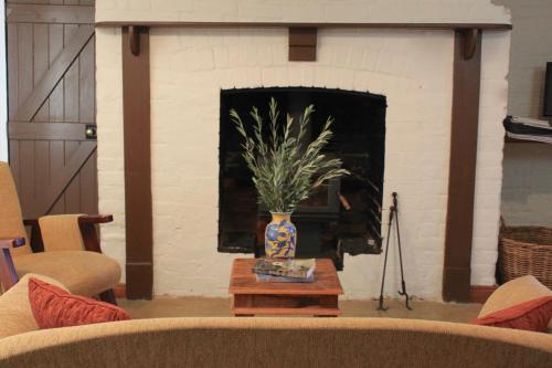 LongfordWoolmers Estate的客厅设有壁炉,餐桌上摆放着花瓶