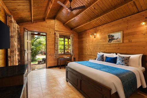 比纳里姆Fortune Resort Benaulim, Goa - Member ITC's Hotel Group的木制客房内的一间卧室配有一张大床