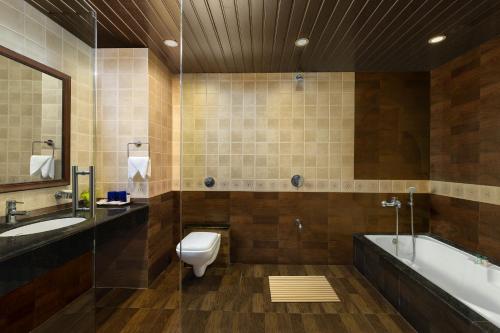 比纳里姆Fortune Resort Benaulim, Goa - Member ITC's Hotel Group的浴室配有卫生间、浴缸和水槽。