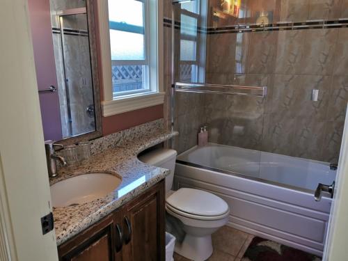 里士满Nini Sweet home的浴室配有盥洗盆、卫生间和浴缸。