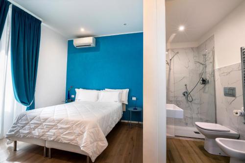 特拉尼Le Marinelle Trani B&B的一间蓝色的卧室,配有一张床和一间浴室