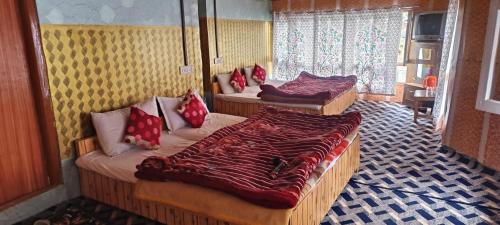 帕哈尔加姆New Snow View Resort pahalgam的一间设有三张床和红色枕头的房间