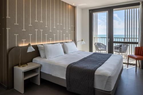 利尼亚诺萨比亚多罗DIVA HOTEL LIGNANO - Adults Only的酒店客房设有一张床和一个阳台。