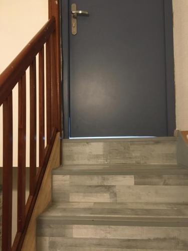 塞纳河畔勒梅Studio chez Virginie et Henri的通往带木台阶的楼梯的门
