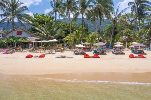 班邦宝Coco Sunset Beach的海滩上设有椅子和遮阳伞,棕榈树