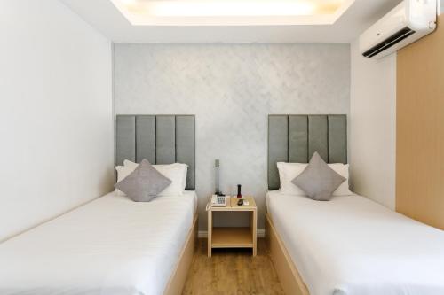 马尼拉丽晶套房大酒店的配有两张床铺的客房设有一张边桌