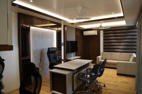 戈尔哈布尔Blisss Hotel Kolhapur的客厅配有沙发和桌椅