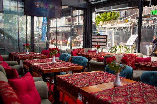 伊斯坦布尔Blue Zerzevan Konak Hotel的餐厅设有桌椅,并种有鲜花