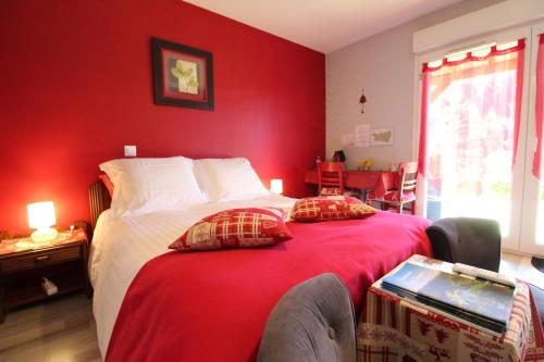 克松吕-隆日梅弗洛瑞戴尔伊甸园住宿加早餐旅馆的一间卧室设有红色的墙壁和一张带两个枕头的床