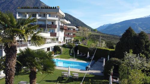 蒂鲁罗Hotel Garni Herz的背景为一座带游泳池和山脉的酒店