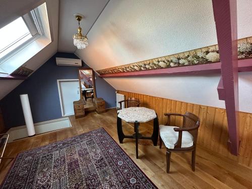 赞丹Het Kraaienest的一间设有桌子和两把椅子的房间和地毯