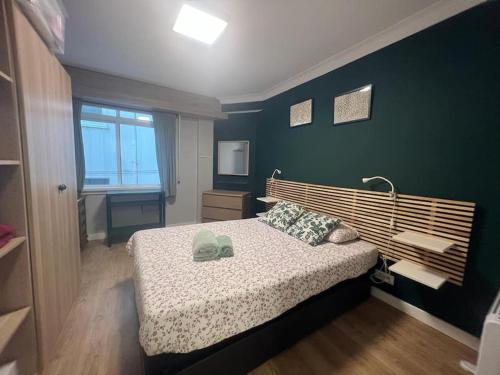 拉科鲁尼亚Vibes Coruña- Estancia moderna en Eiris的一间卧室设有一张床和绿色的墙壁