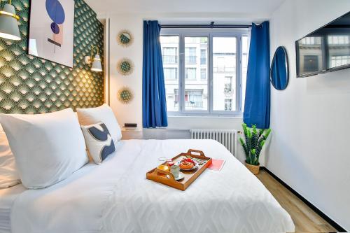 巴黎WS Hôtel de Ville - Beaubourg的一张白色的床,上面放着一盘食物