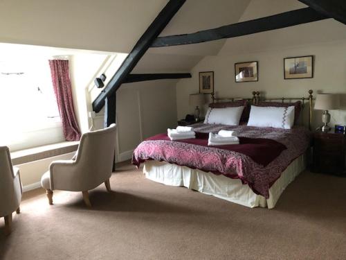 WithypoolThe Royal Oak Inn的一间卧室配有一张大床和一把椅子