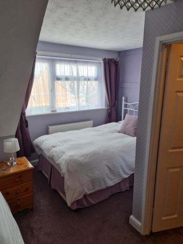 韦茅斯Marden guest house的一间卧室设有一张大床和一个窗户。