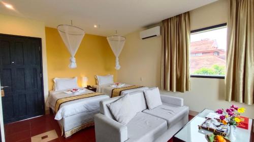 顺化顺化河畔精品SPA度假酒店的酒店客房,设有两张床和一张沙发