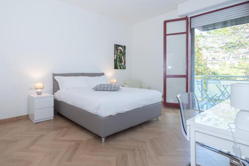 切尔诺比奥Appartamento Rossini - Volta 4的一间白色卧室,配有床和阳台