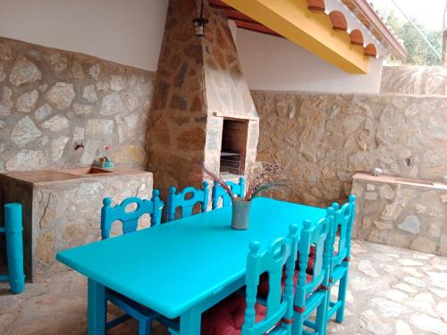 卡斯特里尔Finca Los Villegas的石头墙前的一张蓝色桌子和椅子
