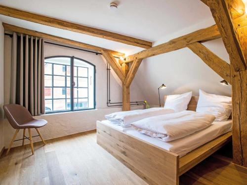 AltenkrempeKultur Gut Hasselburg的一间卧室配有一张木框床和窗户。