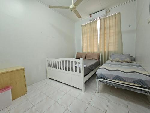 哥打巴鲁Ruhani Homestay 3 KB - 4 Bedroom Fully Airconditioned with WIFI & Netflix的小房间设有婴儿床和床