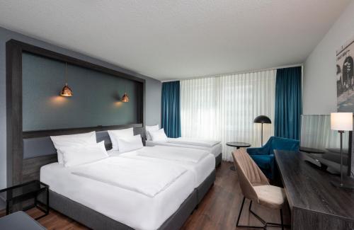 柏林柏林东城市酒店的酒店客房设有一张白色大床和一张书桌
