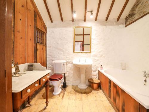 康威The Old Granary的一间带水槽、浴缸和卫生间的浴室