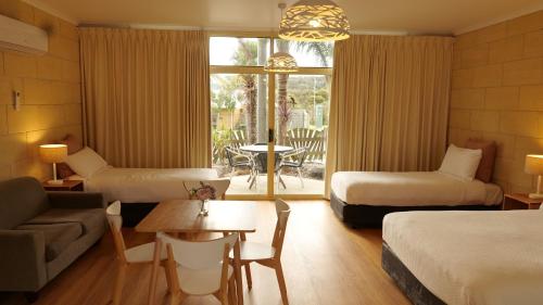 坎贝尔港左舷汽车旅馆的酒店客房设有两张床、一张沙发和一张桌子。