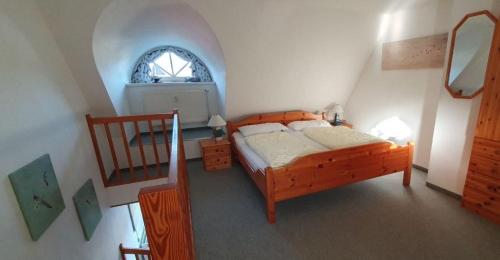 青斯特FeWo Sonnenblume Achtern Diek的一间卧室设有一张床,楼梯设有窗户