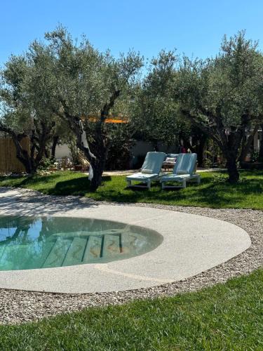 瓦西里科斯THIRES Guesthouse的一个带2把躺椅和桌子的游泳池