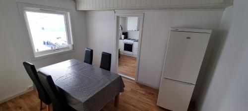 NordmannsetSleep In的厨房配有桌子、冰箱和窗户。