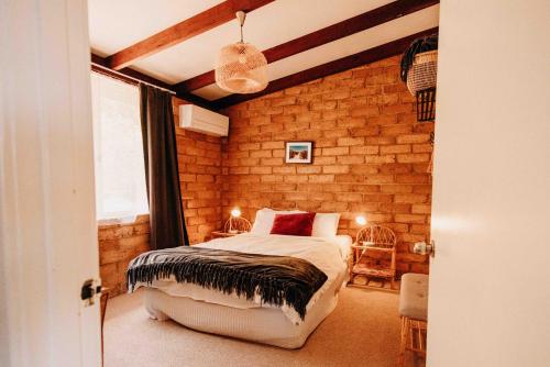 玛格丽特河玛格丽特河度假屋的一间卧室设有一张床和砖墙