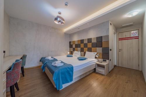 贝尔格莱德Hotel City Code Vizura garni RENEW的卧室配有一张床和一张桌子及椅子