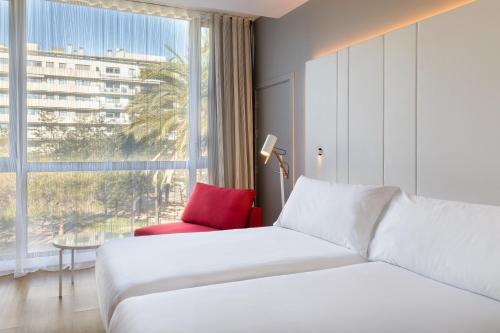 巴塞罗那Occidental Atenea Mar - Adults Only的酒店客房设有床和窗户。