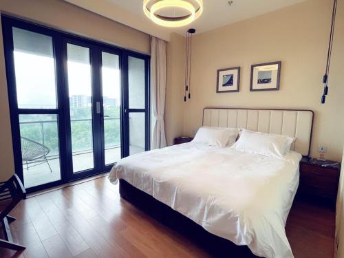 昌黎阿那亚二期地中海式瞰海公寓的卧室设有白色的床和大窗户