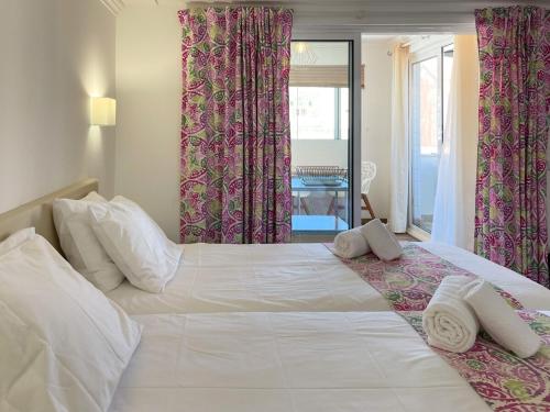 阿尔布费拉Sofeelings, Estudio Sol, Baixa de Albufeira的卧室配有一张白色大床和粉红色窗帘