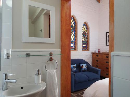 Nieu-BethesdaBethesda Tower Accommodation的一间带水槽和蓝色椅子的浴室