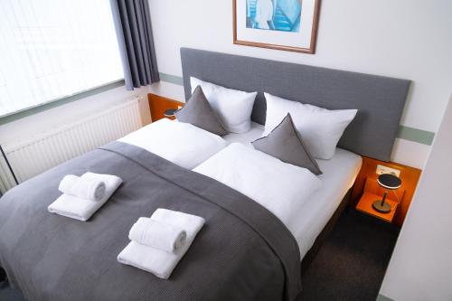 弗希塔HOTEL BREMER TOR, Bestes Hotelfrühstück, Self-Check-In 24 h的一间卧室配有一张大床,上面有白色毛巾