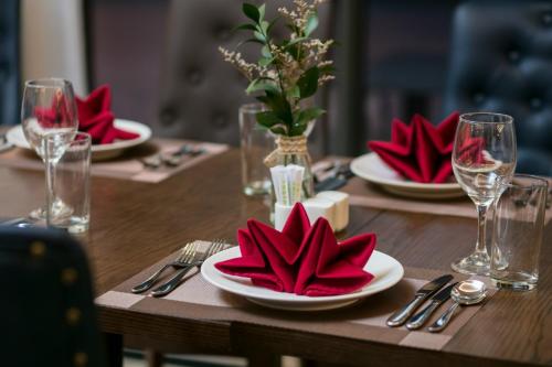 下龙湾Halios Luxury Halong Hotel的一张木桌,上面有红色的餐巾和盘子