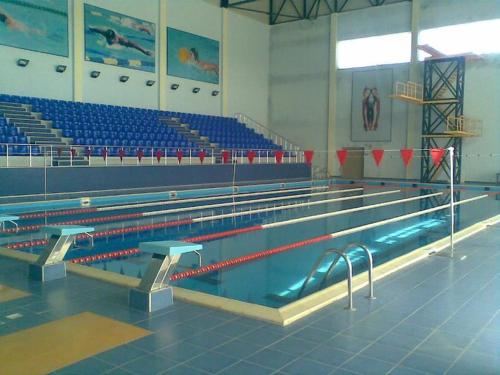 库萨雷Qusar Olimpik Hotel and Cottages的蓝色座椅的健身房里的一个空游泳池
